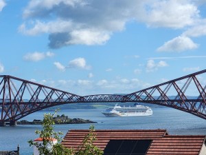 A train bridge over the Firth of Forth Scotland, with a cruise ship in the background