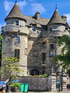 The front entrance to the Falkland Palace, with turrets and lots of windows facing the street