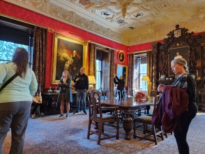 An image of a dining room with red walls and several people looking around
