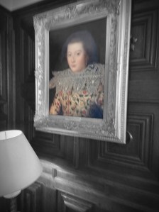 A mostly black and white photo of a painting of a woman in a yellow dress. I think this is the Green Lady.