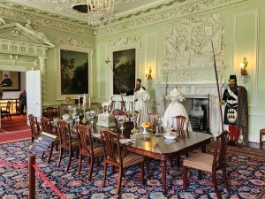 A large dining table in a soft green room