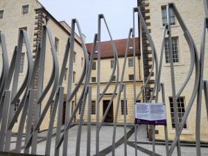 A view of the Scottish Parliament from outside the tall gates