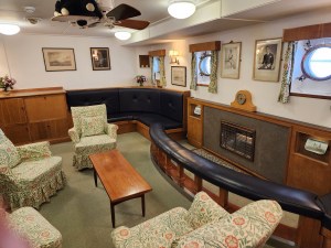 A room with several overstuffed chairs, a coffee table, and a fireplace.