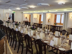 The dining table in the great hall. It is set with lovely china and silverware.