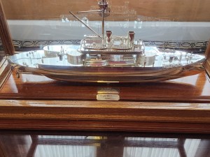 A small silver model of the HMS Thunderer (1872) behind glass