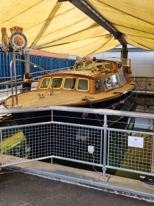 A speedboat sits under an awning